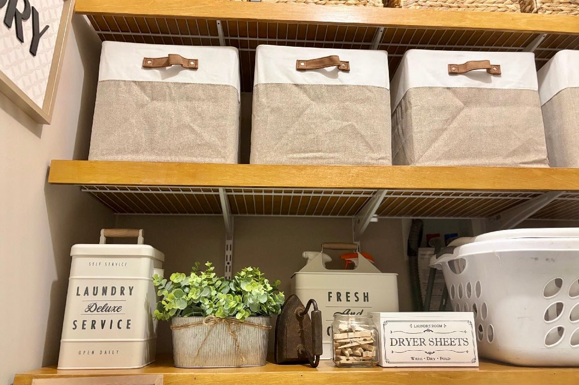 Shelving unit with storage bins, laundry basket, and decorative items in a laundry room.